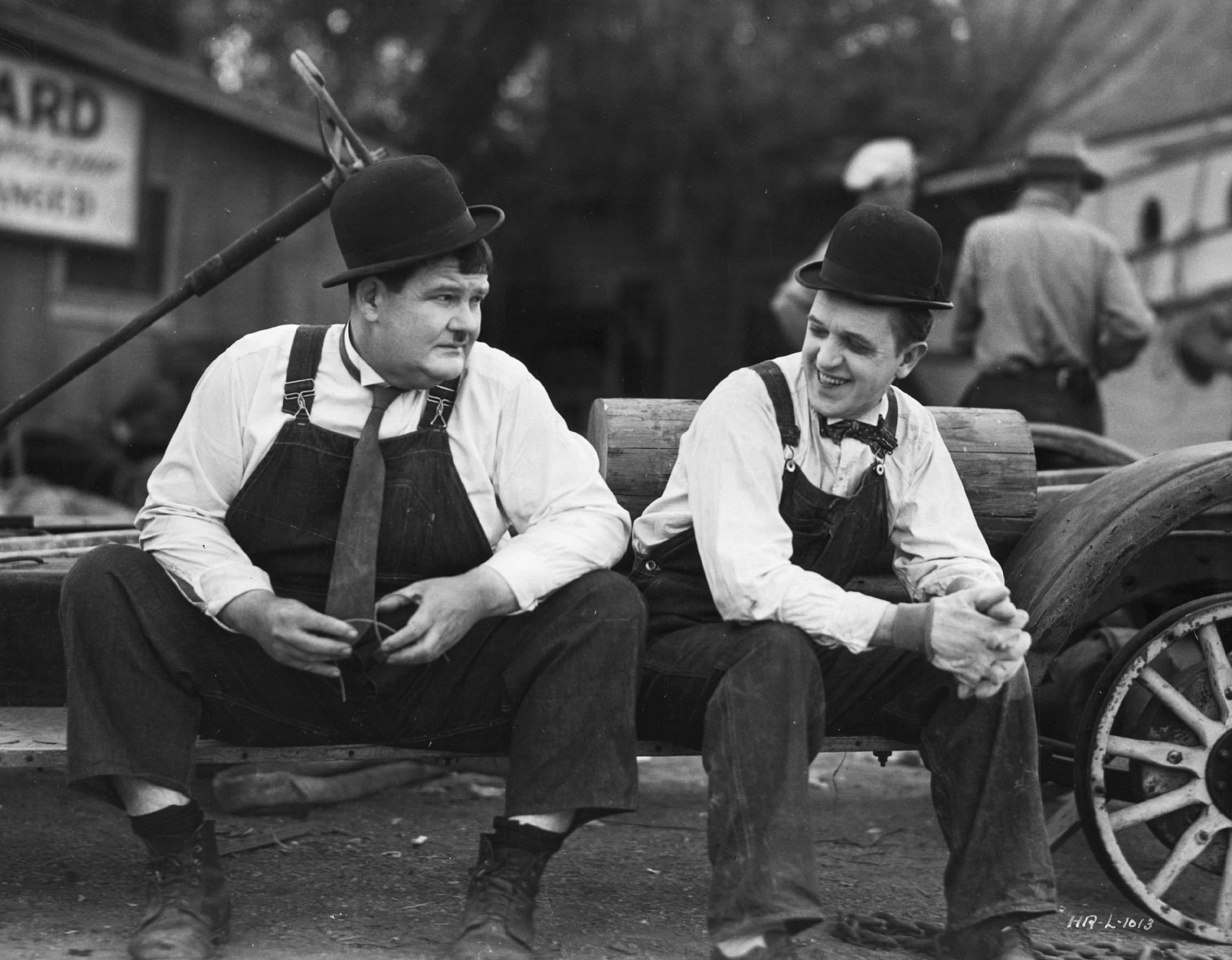 Stan Laurel and Oliver Hardy take a break during the filming of the Hal Roach production of "Towed In A Hole", 1932