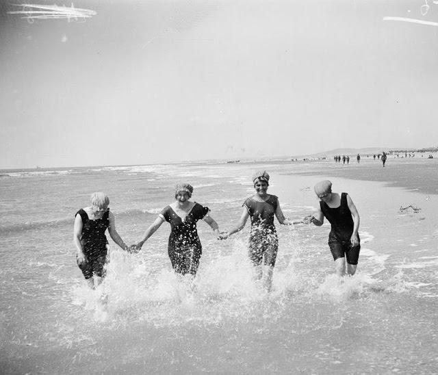 4 Women enjoying at beach with differnt bathing suits, 1912