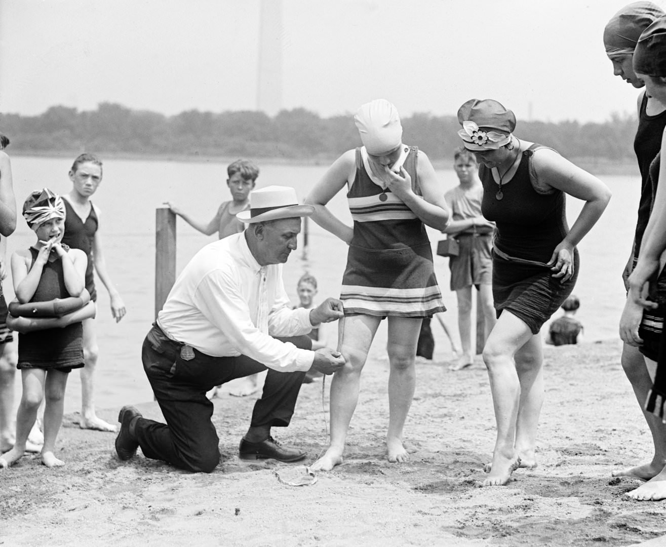 Woman having her swimsuit measured for length violations on a Washington DC beach, 1922