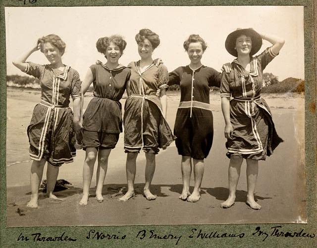 Women wearing 1900s swimsuits having right down to the collars and buttons made from heavy flannel or wool fabrics