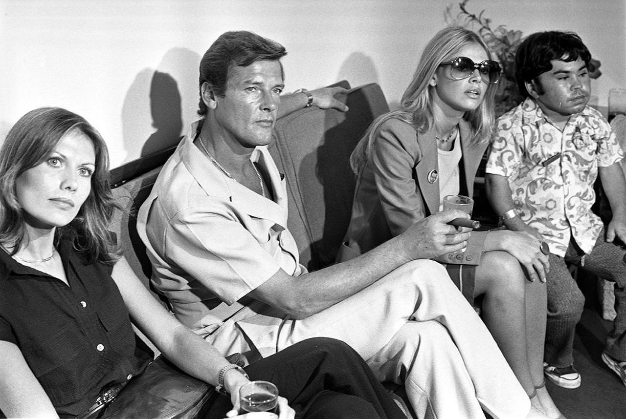 Maud Adams, Roger Moore, Britt Ekland and Hervé Villechaize during the filming of “The Man With The Golden Gun”, Hong Kong, 1974