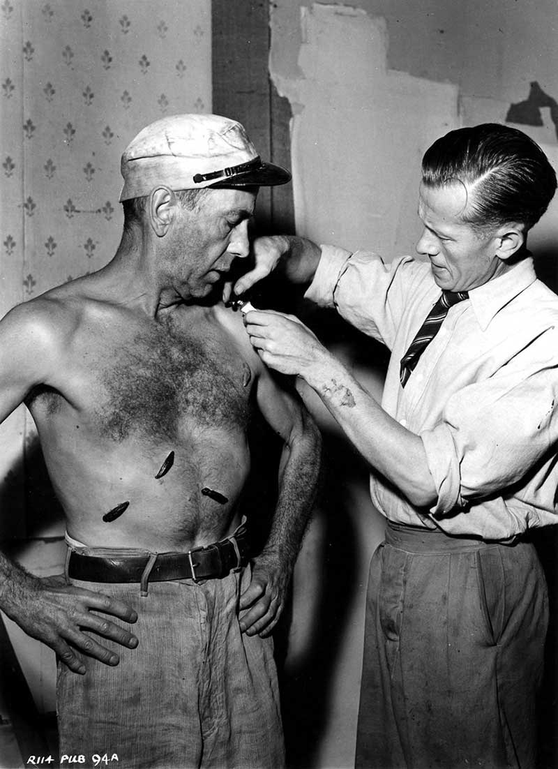 Humphrey Bogart having rubber leeches applied to his chest for the filming of "The African Queen", 1951