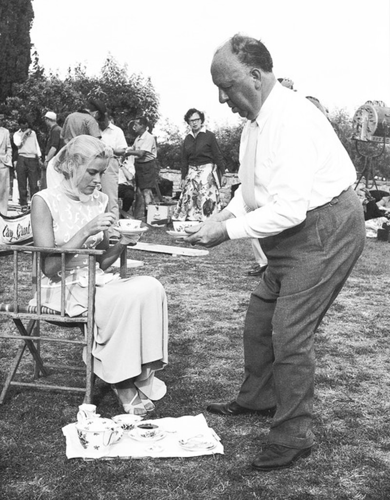 Alfred Hitchcock serving Grace Kelly tea on the set of "To Catch a Thief" , 1955