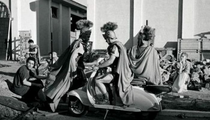 A Roman centurion sits on a Vespa in between takes during the filming of Ben-Hur, 1959