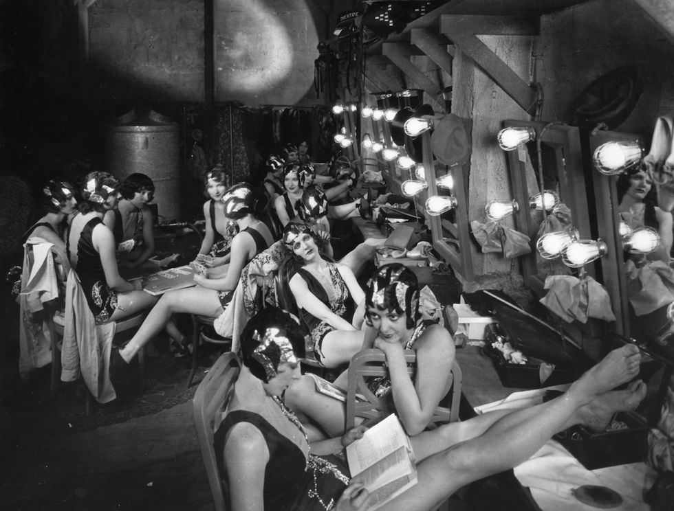 Chorus girls relaxing in the dressing room between scenes during the filming of 'Broadway', 1928