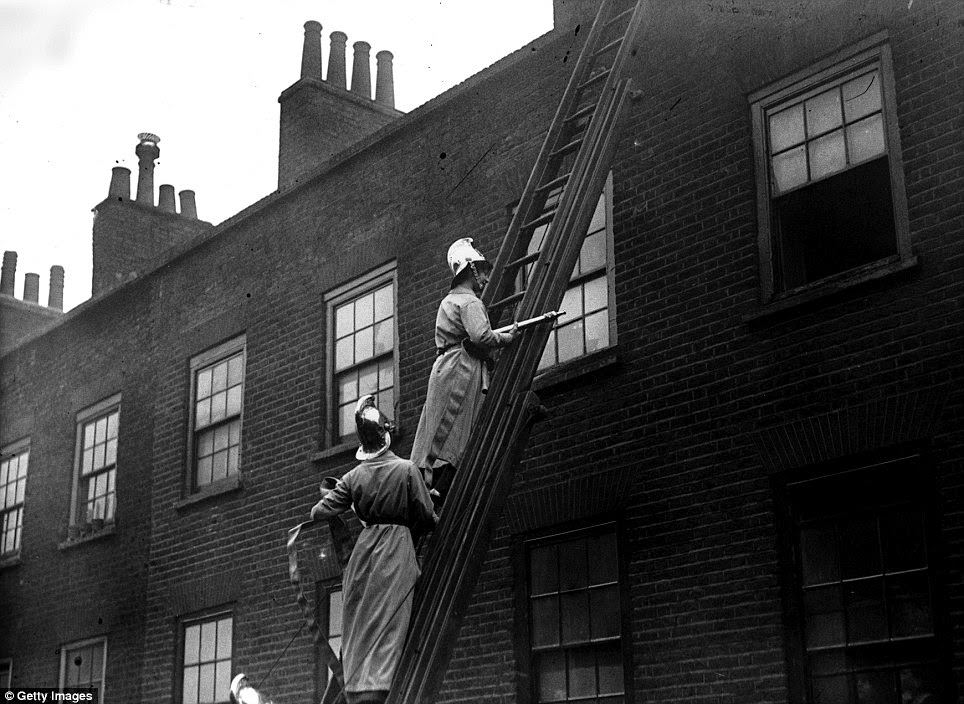 Members of the Women’s Fire Brigade are put through their paces during a fire drill with hoses and extinguishers at full force in March 1916.