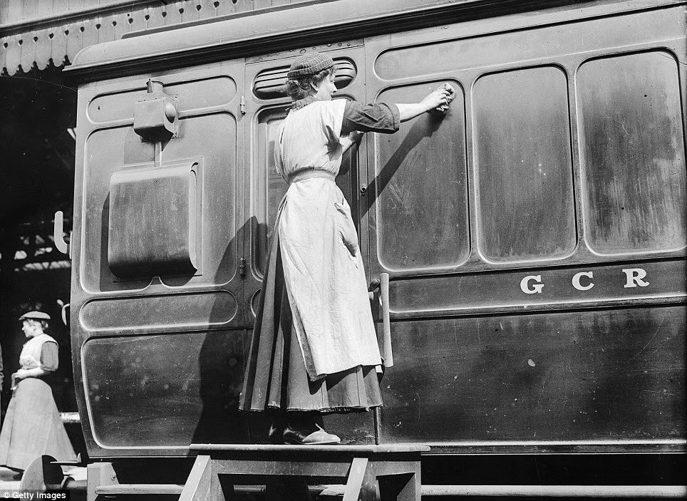 A member of the Women Porters At Marylebone Station Group, pictured in 1914 giving a Great Central Railways carriage a thorough clean.