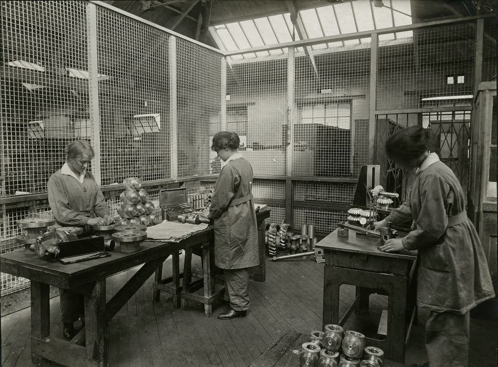 Women inspecting motor engine parts