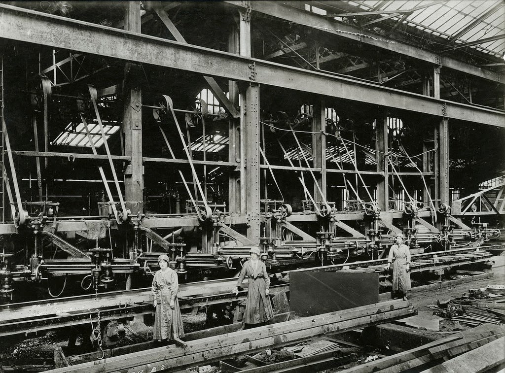 Women operating radial drilling machines, drilling holes in girders