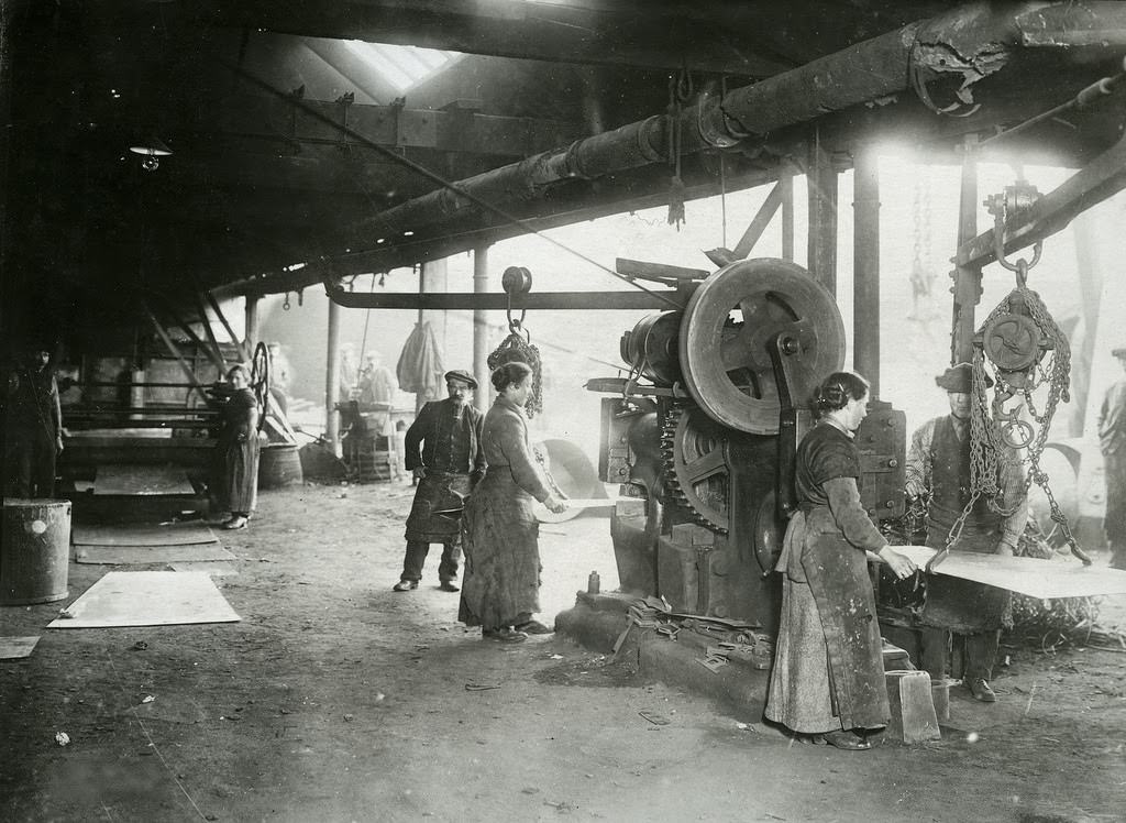 Woman acting as helper at punching and shearing machine