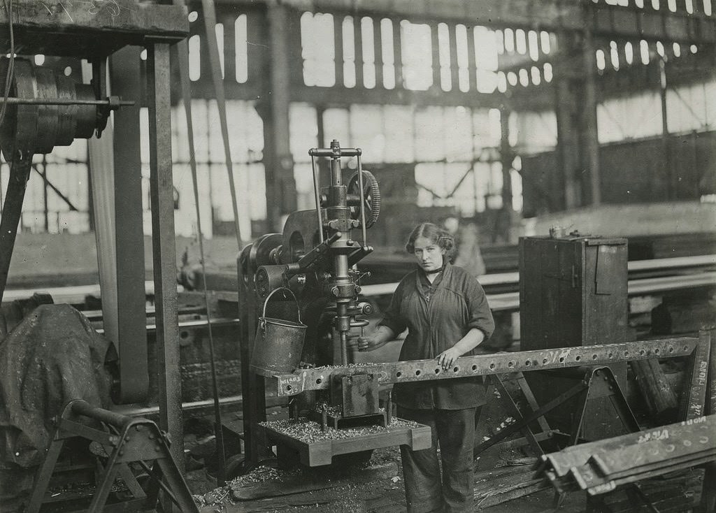 Woman operating vertical drilling machines, drilling angles for connections to ribs of airship sheds