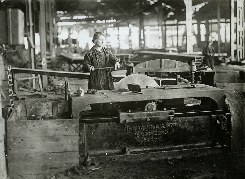 Women operating circular saw, cutting steel bar