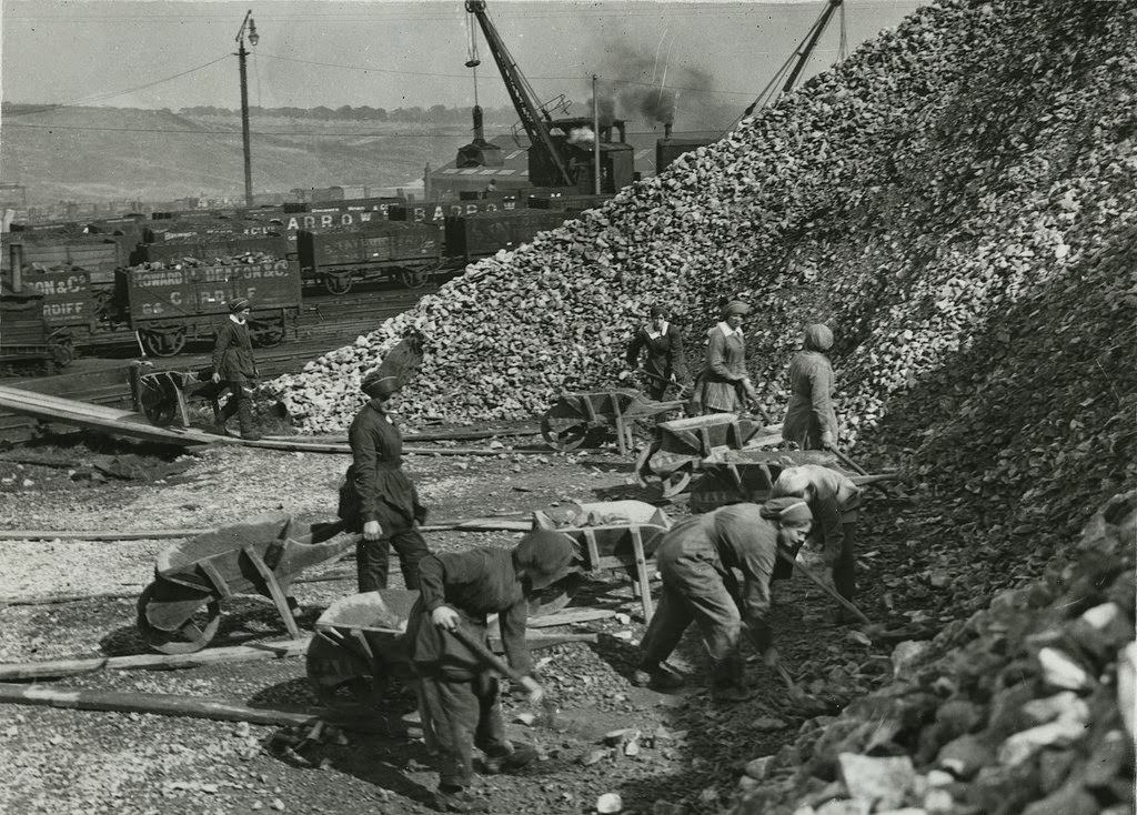 British women chemical workers in the Midlands taking limestone from stock, loading and wheeling barrows of lime to wagons