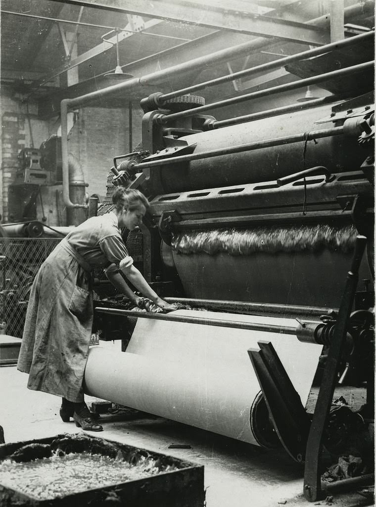 British rubber workers in Lancashire spreading machine for coaling canvas for tire making
