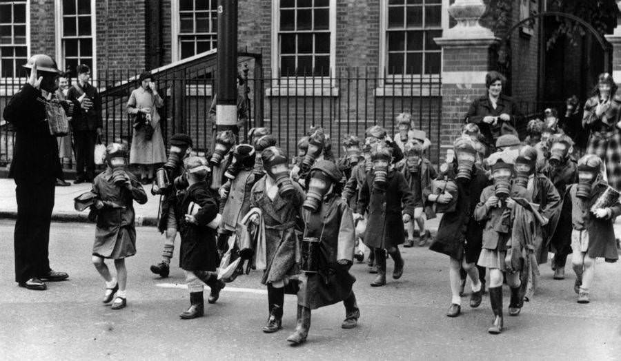A horde of children wearing gas masks carry out a practice evacuation of a school in Kingston, Greater London, after a canister of tear gas was discharged. 1941.