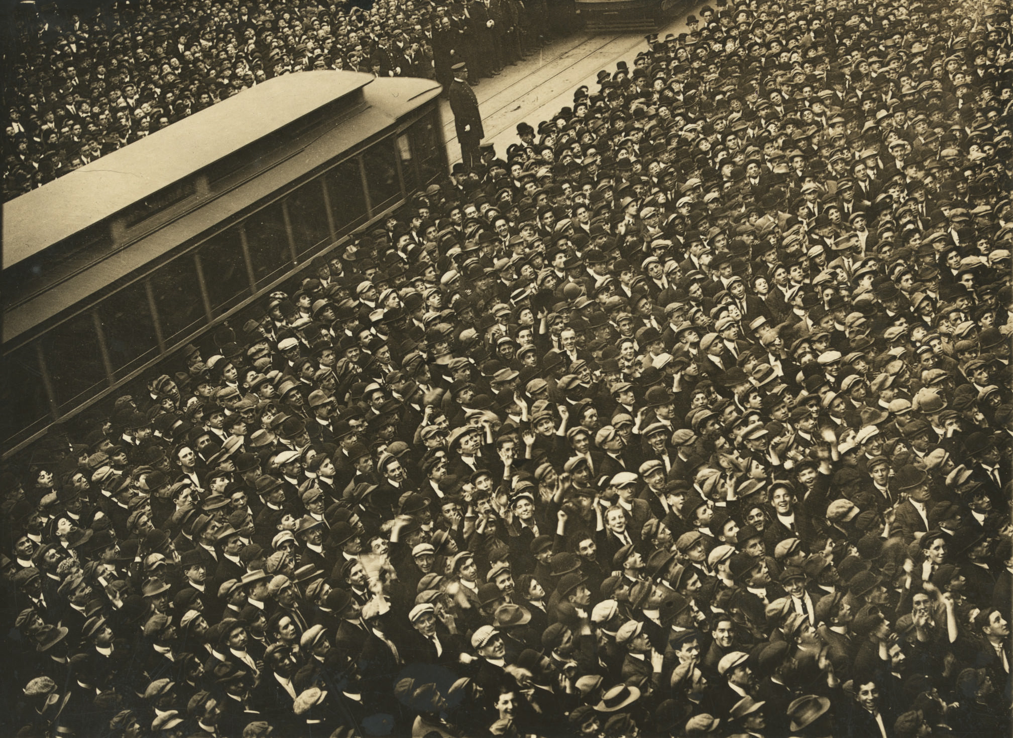 A multitude of humanity stands outside the New York Herald Building watching the Play-O-Graph