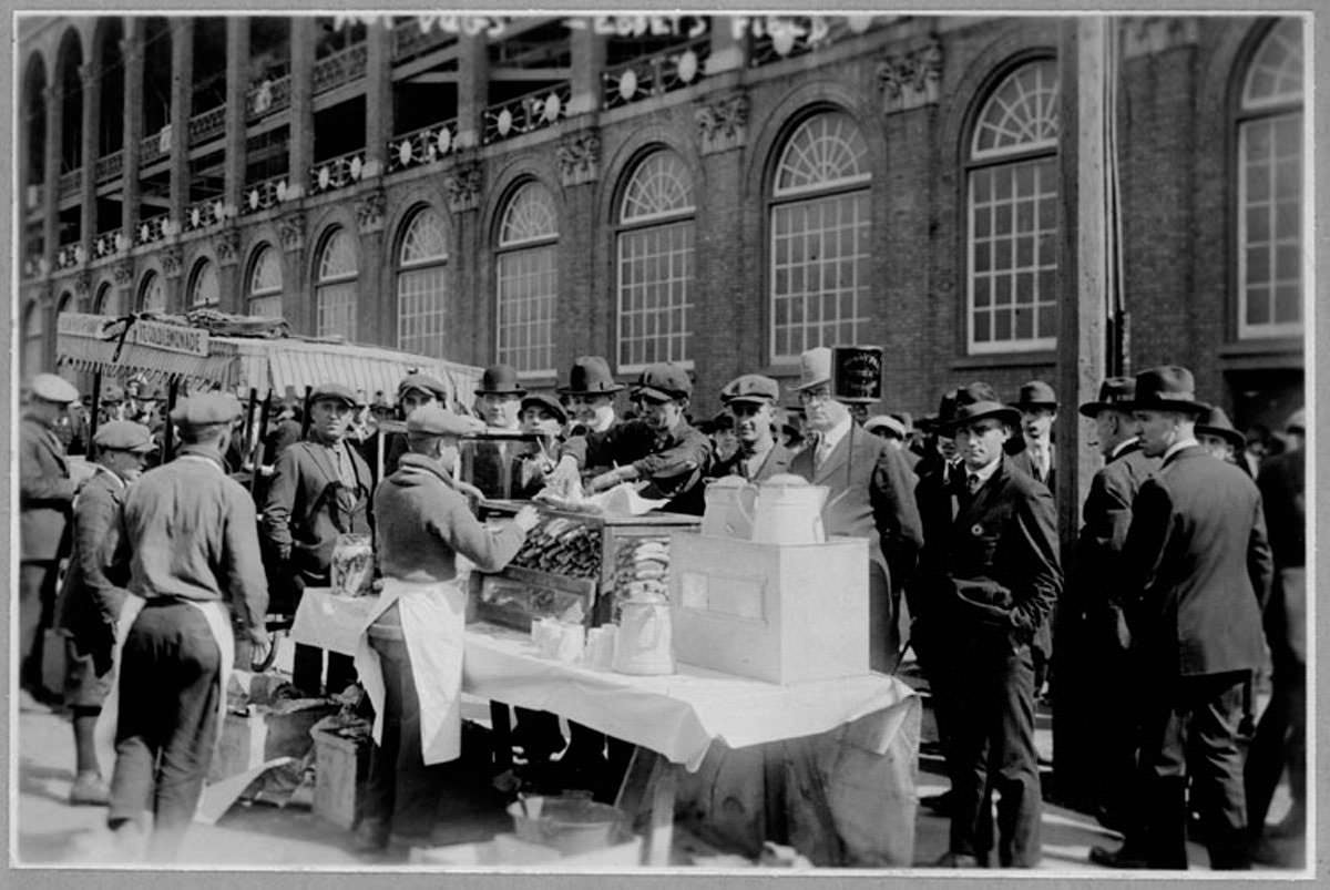 Baseball fans enjoying hot dogs while waiting for gates to open at Ebbets Field, 1920