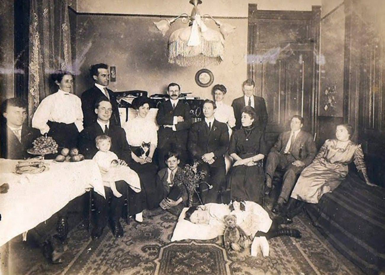 Dead girl is  is lying on the floor of the parlor surrounded by family members.