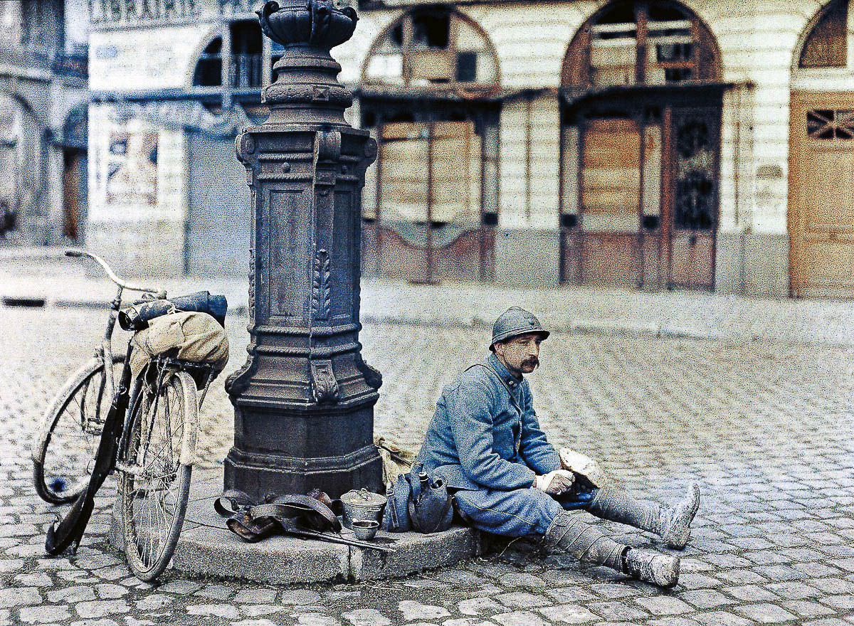 A French soldier eats a loaf of bread in Reims, France, 1917