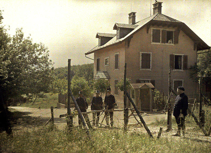 At the Swiss border: Swiss soldiers, a French soldier and a woman at his window. Switzerland, 1917