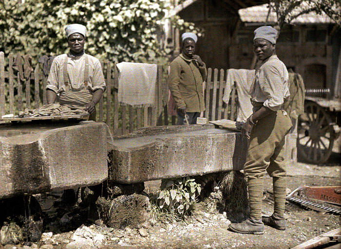 Senegalese military washing clothes in troughs. France, 1917