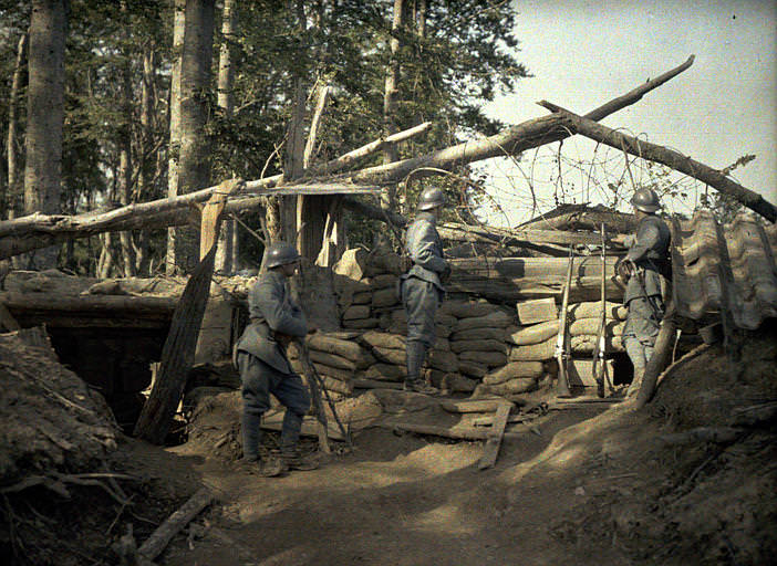 Front line trench observation post: three French soldiers under observation behind sandbags. France, 1917