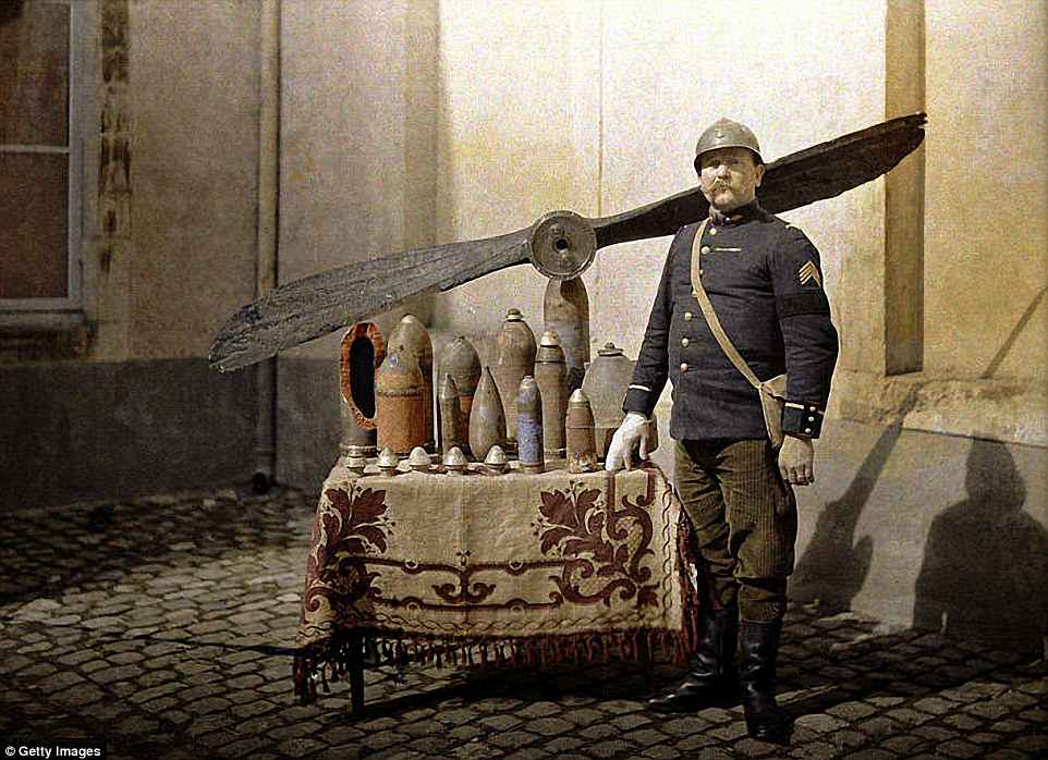 A French soldier stands by a table which has German grenades and an aircraft propeller on it, in Reims, France, in 1917