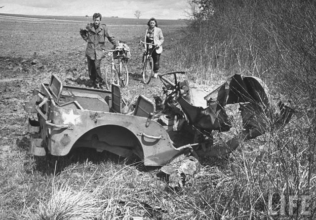 Ernest Kreiling and his bride looking at a wrecked jeep during tour of battlefields.