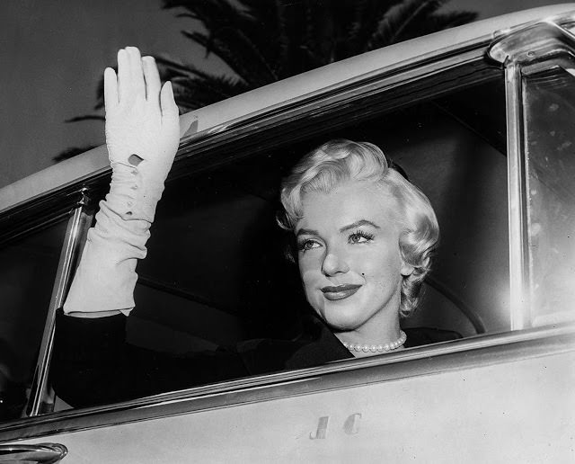 arilyn Monroe waves to fans while leaving court following divorce from Joe Demaggio, 1954