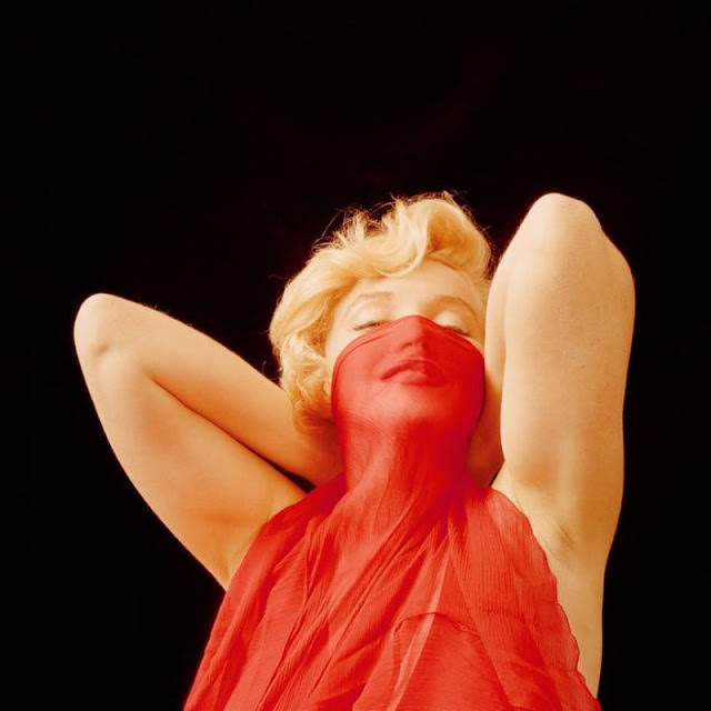 Marilyn Monroe playfully poses during the 'The Red Dress Sitting' Series, January 1957