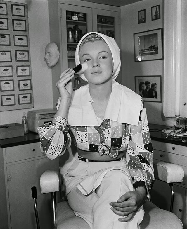 Marilyn preps her skin with a skin brush before applying makeup, 1948