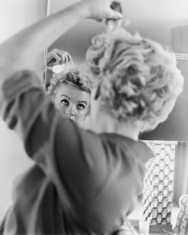 Marilyn checking her infamous culrs, 1951