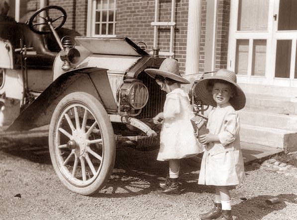 Twin girls getting ready to go in the car, 1914