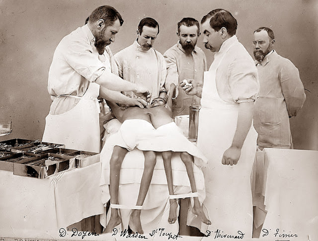 An operating room where doctors are attempting to separate the twins, 1902