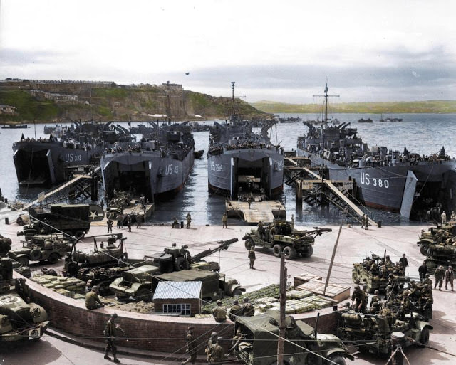 Troops load U.S. LSTs with artillery equipment, vehicles and troops in Brixham, England before they head for Normandy.