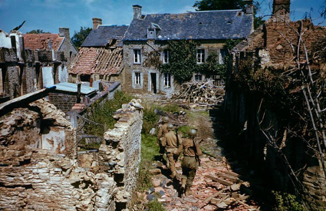 Troops searching ruined homes in western France after D-Day.