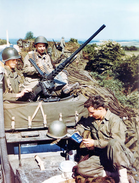 Operation Overlord Normandy, United States Army soldiers are sitting on top of several M4 half-track armored personal carriers.