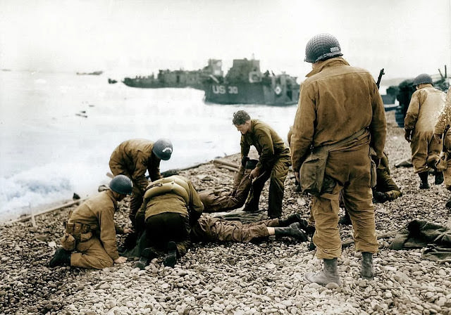 Allied troops exiting a landing craft in trucks on a beachhead during the D-Day landings in Normandy, France.