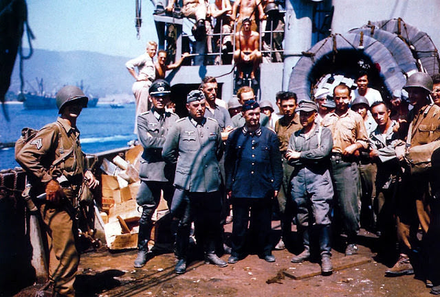 American troops with German prisoners of war on board a Liberty ship in the English Channel during the Allied invasion of Normandy.