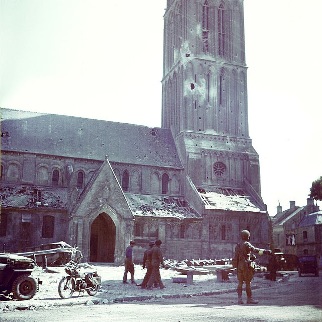 A Canadian soldier directs traffic in front of the Notre-Dame Nativity church, in Bernieres-sur-Mer.