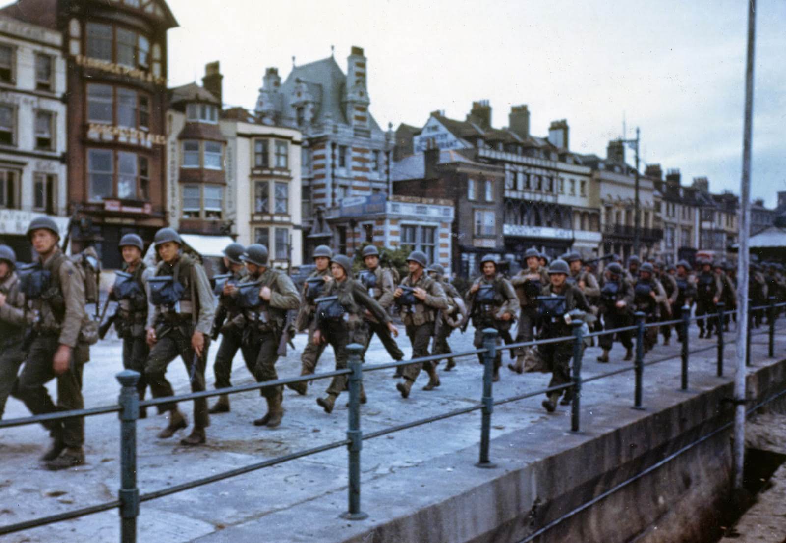 These American troops are marching through the streets of a British port town on their way to the docks where they will be loaded into landing craft for the big assault.