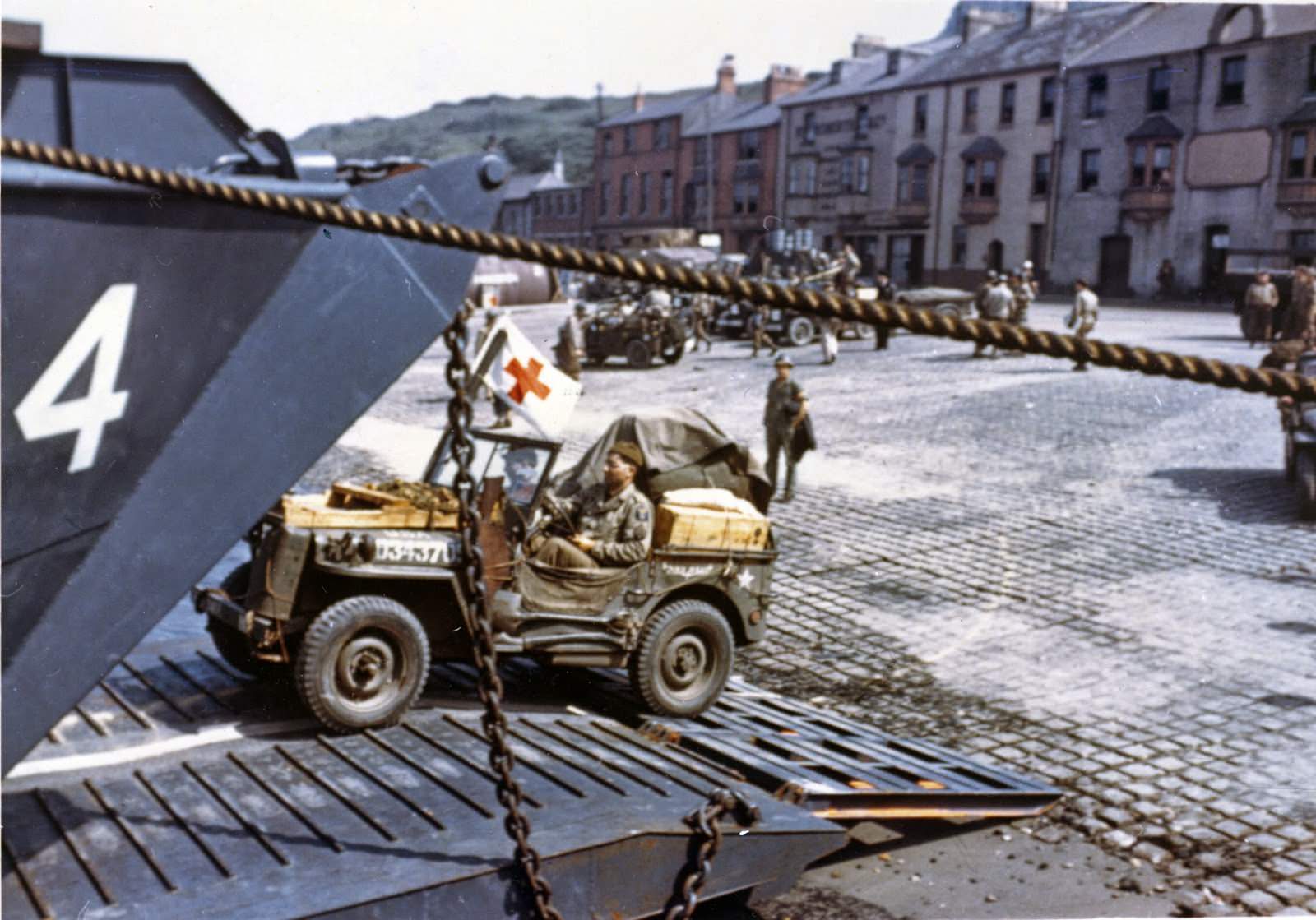 Jeeps being driven into the open doors of an LCT at a port in Britain in preparation for D-Day.