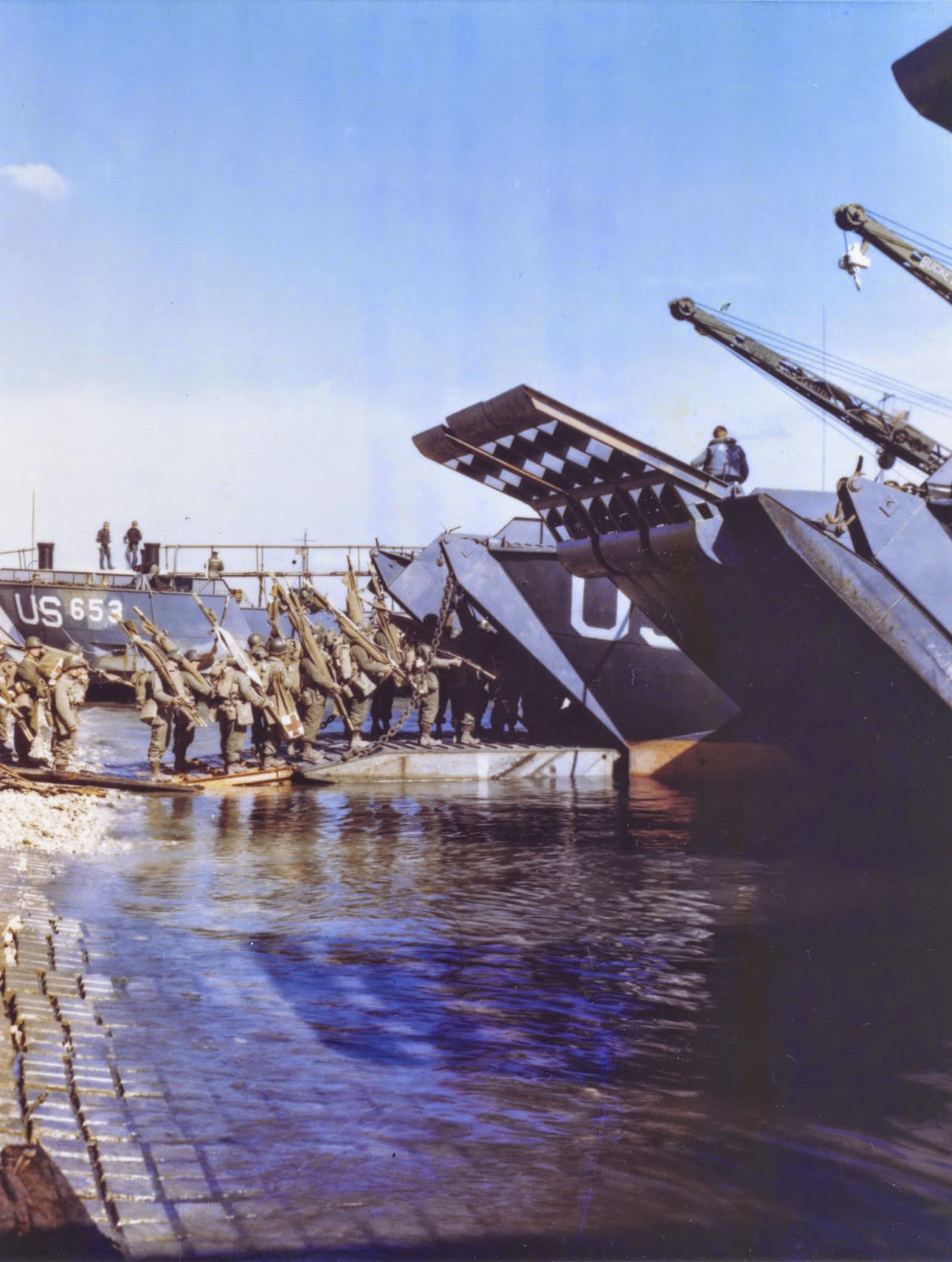 Medics and litter bearers going up the ramp of an LCT which will take them to France for the assault against Hitler’s Europe.