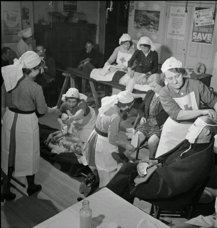 A busy scene in the Treatment Room of the First Aid Post, set up in a room in a school, probably Mary Boon School, on the corner of Earsby Street and Bishop King's Road, near Avonmore Road, London, 1942.