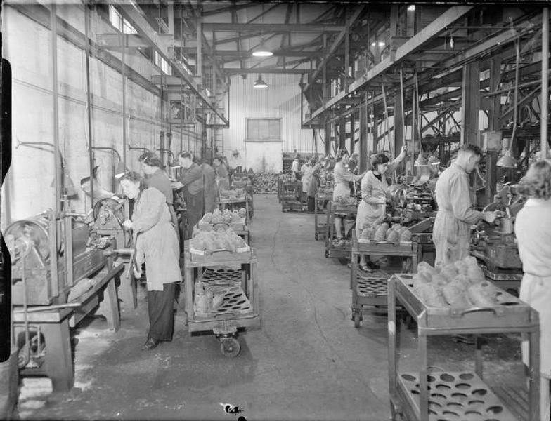 Workers at the small factory of J & F Pool Ltd operate lathes to bore and face the nose ends of mortar bombs, 1943.