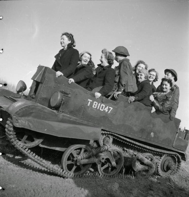 Women war workers from J & F Pool Ltd, a small West Country arms factory, travel to a test range in a Universal carrier, Mark I, 1943.