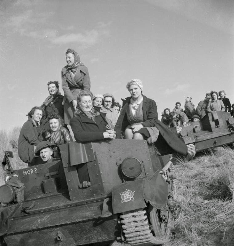 Women war workers from J & F Pool Ltd, a small West Country arms factory, travel to a test range in a Universal carrier, Mark I, 1943.