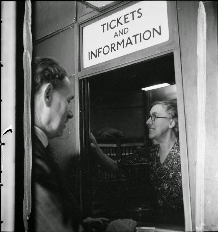 Rose Pillon offers advice to a passengers from the 'Tickets and Information' window at this London Underground station, 1942.
