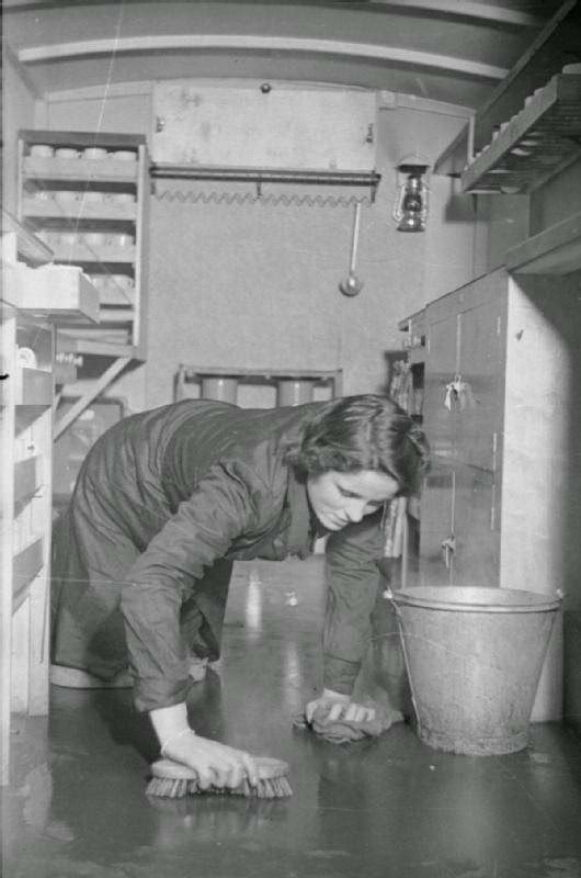 Rachel Bingham scrubs the floor of the WVS canteen on her return to the Canteen Service depot, somewhere in London in 1941.