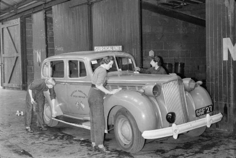 Women of the American Ambulance Great Britain wash an ambulance car of the surgical unit to pass the time between call-outs at their depot, somewhere in London, 1944.
